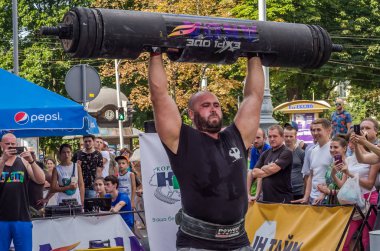 Lviv, Ukrayna - Ağustos 2017: Güçlü bir atlet hayran Strongmen Oyunları'nda seyirci önünde başını halter bir büyük ağır toparlayabiliriz alır