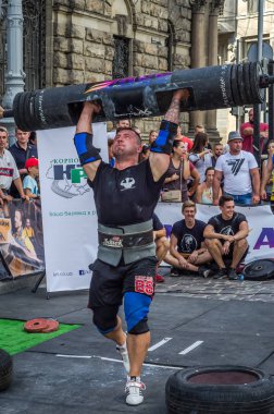 Lviv, Ukrayna - Ağustos 2017: Güçlü bir atlet hayran Strongmen Oyunları'nda seyirci önünde başını halter bir büyük ağır toparlayabiliriz alır