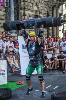 Lviv, Ukrayna - Ağustos 2017: Güçlü bir atlet hayran Strongmen Oyunları'nda seyirci önünde başını halter bir büyük ağır toparlayabiliriz alır
