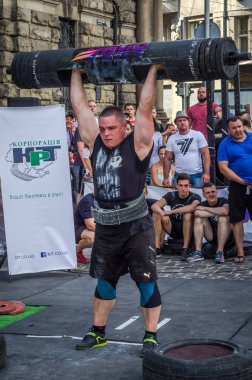 Lviv, Ukrayna - Ağustos 2017: Güçlü bir atlet hayran Strongmen Oyunları'nda seyirci önünde başını halter bir büyük ağır toparlayabiliriz alır