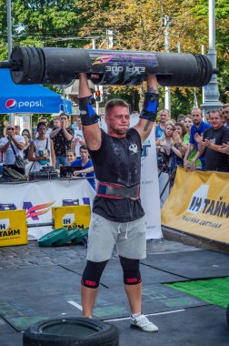 Lviv, Ukrayna - Ağustos 2017: Güçlü bir atlet hayran Strongmen Oyunları'nda seyirci önünde başını halter bir büyük ağır toparlayabiliriz alır