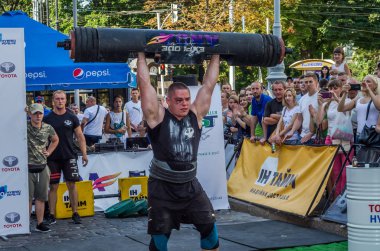 Lviv, Ukrayna - Ağustos 2017: Güçlü bir atlet hayran Strongmen Oyunları'nda seyirci önünde başını halter bir büyük ağır toparlayabiliriz alır