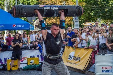 Lviv, Ukrayna - Ağustos 2017: Güçlü bir atlet hayran Strongmen Oyunları'nda seyirci önünde başını halter bir büyük ağır toparlayabiliriz alır