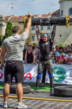 Lviv, Ukrayna - Ağustos 2017: Güçlü bir atlet hayran Strongmen Oyunları'nda seyirci önünde başını halter bir büyük ağır toparlayabiliriz alır