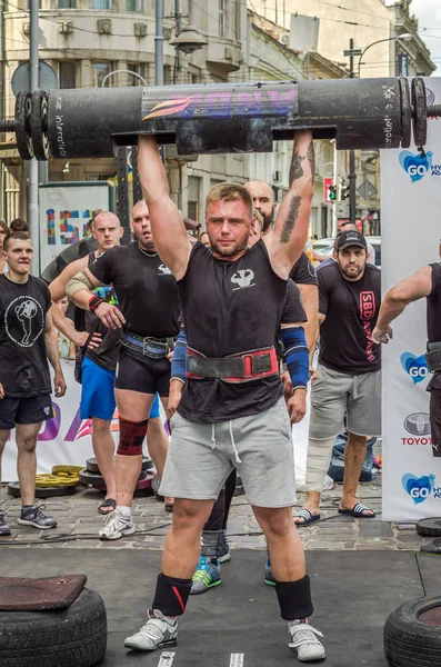 Lviv, Ukrayna - Ağustos 2017: Güçlü bir atlet hayran Strongmen Oyunları'nda seyirci önünde başını halter bir büyük ağır toparlayabiliriz alır