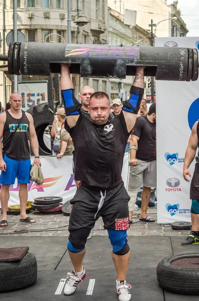 Lviv, Ukrayna - Ağustos 2017: Güçlü bir atlet hayran Strongmen Oyunları'nda seyirci önünde başını halter bir büyük ağır toparlayabiliriz alır