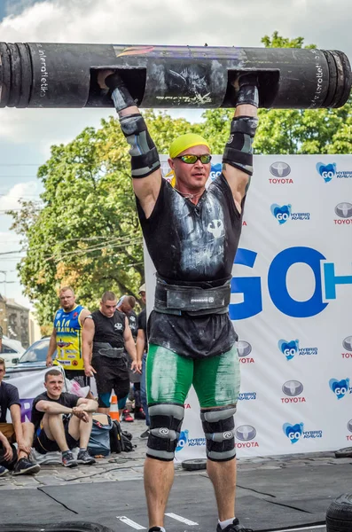 Lviv, Ukrayna - Ağustos 2017: Güçlü bir atlet hayran Strongmen Oyunları'nda seyirci önünde başını halter bir büyük ağır toparlayabiliriz alır