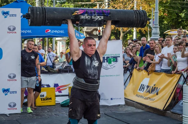 Lviv, Ukrayna - Ağustos 2017: Güçlü bir atlet hayran Strongmen Oyunları'nda seyirci önünde başını halter bir büyük ağır toparlayabiliriz alır