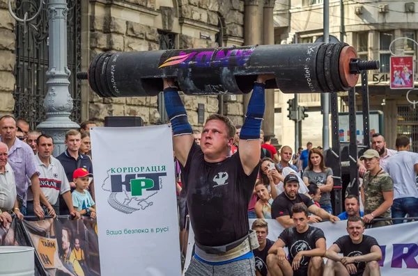 Lviv, Ukrayna - Ağustos 2017: Güçlü bir atlet hayran Strongmen Oyunları'nda seyirci önünde başını halter bir büyük ağır toparlayabiliriz alır