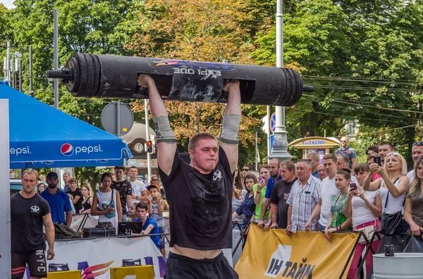 Lviv, Ukrayna - Ağustos 2017: Güçlü bir atlet hayran Strongmen Oyunları'nda seyirci önünde başını halter bir büyük ağır toparlayabiliriz alır