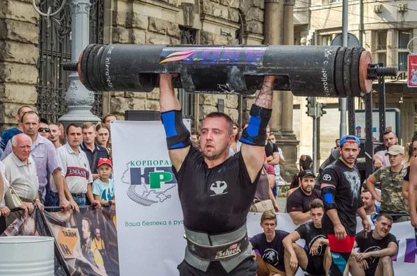 Lviv, Ukrayna - Ağustos 2017: Güçlü bir atlet hayran Strongmen Oyunları'nda seyirci önünde başını halter bir büyük ağır toparlayabiliriz alır