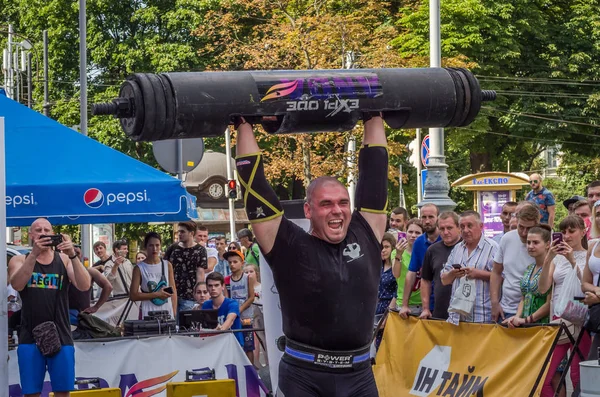 Lviv, Ukrayna - Ağustos 2017: Güçlü bir atlet hayran Strongmen Oyunları'nda seyirci önünde başını halter bir büyük ağır toparlayabiliriz alır