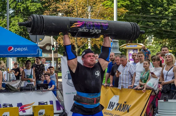 Lviv, Ukrayna - Ağustos 2017: Güçlü bir atlet hayran Strongmen Oyunları'nda seyirci önünde başını halter bir büyük ağır toparlayabiliriz alır