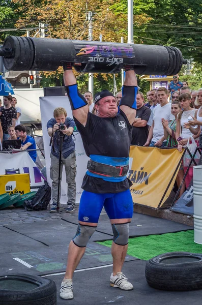 Lviv, Ukrayna - Ağustos 2017: Güçlü bir atlet hayran Strongmen Oyunları'nda seyirci önünde başını halter bir büyük ağır toparlayabiliriz alır