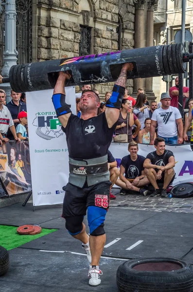 Lviv, Ukrayna - Ağustos 2017: Güçlü bir atlet hayran Strongmen Oyunları'nda seyirci önünde başını halter bir büyük ağır toparlayabiliriz alır