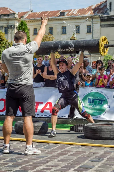 Lviv, Ukrayna - Ağustos 2017: Güçlü bir atlet hayran Strongmen Oyunları'nda seyirci önünde başını halter bir büyük ağır toparlayabiliriz alır