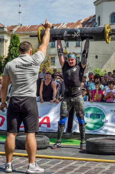 Lviv, Ukrayna - Ağustos 2017: Güçlü bir atlet hayran Strongmen Oyunları'nda seyirci önünde başını halter bir büyük ağır toparlayabiliriz alır