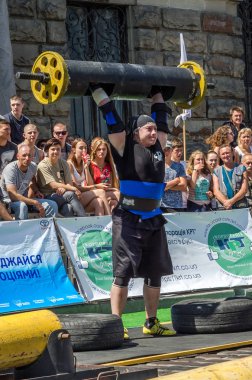 Lviv, Ukrayna - Ağustos 2017: Güçlü bir atlet hayran Strongmen Oyunları'nda seyirci önünde başını halter bir büyük ağır toparlayabiliriz alır