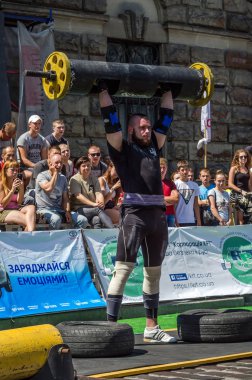 Lviv, Ukrayna - Ağustos 2017: Güçlü bir atlet hayran Strongmen Oyunları'nda seyirci önünde başını halter bir büyük ağır toparlayabiliriz alır