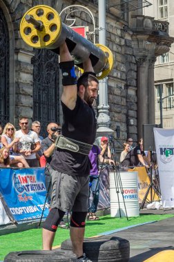 Lviv, Ukrayna - Ağustos 2017: Güçlü bir atlet hayran Strongmen Oyunları'nda seyirci önünde başını halter bir büyük ağır toparlayabiliriz alır