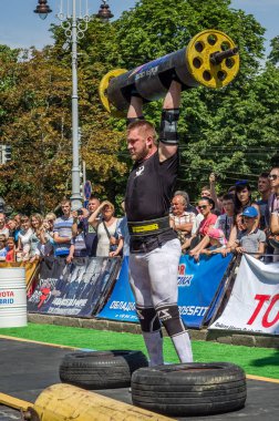 Lviv, Ukrayna - Ağustos 2017: Güçlü bir atlet hayran Strongmen Oyunları'nda seyirci önünde başını halter bir büyük ağır toparlayabiliriz alır