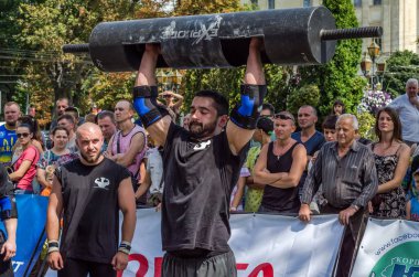 Lviv, Ukrayna - Ağustos 2017: Güçlü bir atlet hayran Strongmen Oyunları'nda seyirci önünde başını halter bir büyük ağır toparlayabiliriz alır