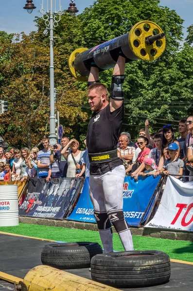 Lviv, Ukrayna - Ağustos 2017: Güçlü bir atlet hayran Strongmen Oyunları'nda seyirci önünde başını halter bir büyük ağır toparlayabiliriz alır