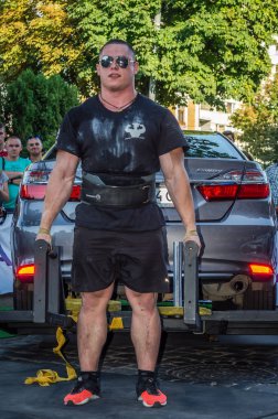 Lviv, Ukrayna - Ağustos 2017: Güçlü atlet vücut geliştirmeci Strongmen maçta coşkulu seyirci önünde Toyota otomobil asansörleri