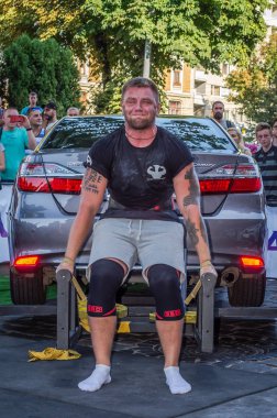 Lviv, Ukrayna - Ağustos 2017: Güçlü atlet vücut geliştirmeci Strongmen maçta coşkulu seyirci önünde Toyota otomobil asansörleri