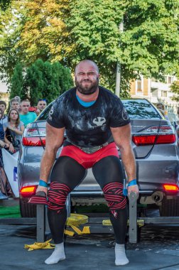 Lviv, Ukrayna - Ağustos 2017: Güçlü atlet vücut geliştirmeci Strongmen maçta coşkulu seyirci önünde Toyota otomobil asansörleri