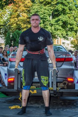 Lviv, Ukrayna - Ağustos 2017: Güçlü atlet vücut geliştirmeci Strongmen maçta coşkulu seyirci önünde Toyota otomobil asansörleri