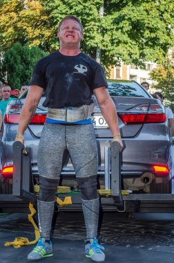 Lviv, Ukrayna - Ağustos 2017: Güçlü atlet vücut geliştirmeci Strongmen maçta coşkulu seyirci önünde Toyota otomobil asansörleri