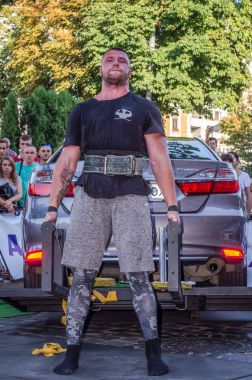 Lviv, Ukrayna - Ağustos 2017: Güçlü atlet vücut geliştirmeci Strongmen maçta coşkulu seyirci önünde Toyota otomobil asansörleri