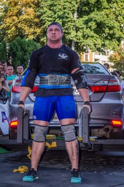 Lviv, Ukrayna - Ağustos 2017: Güçlü atlet vücut geliştirmeci Strongmen maçta coşkulu seyirci önünde Toyota otomobil asansörleri