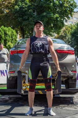 Lviv, Ukrayna - Ağustos 2017: Güçlü atlet vücut geliştirmeci Strongmen maçta coşkulu seyirci önünde Toyota otomobil asansörleri