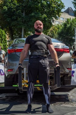Lviv, Ukrayna - Ağustos 2017: Güçlü atlet vücut geliştirmeci Strongmen maçta coşkulu seyirci önünde Toyota otomobil asansörleri