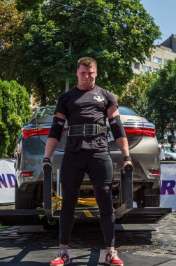 Lviv, Ukrayna - Ağustos 2017: Güçlü atlet vücut geliştirmeci Strongmen maçta coşkulu seyirci önünde Toyota otomobil asansörleri