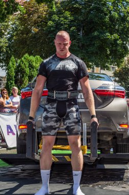 Lviv, Ukrayna - Ağustos 2017: Güçlü atlet vücut geliştirmeci Strongmen maçta coşkulu seyirci önünde Toyota otomobil asansörleri