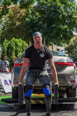 Lviv, Ukrayna - Ağustos 2017: Güçlü atlet vücut geliştirmeci Strongmen maçta coşkulu seyirci önünde Toyota otomobil asansörleri