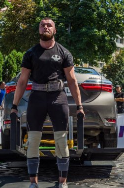 Lviv, Ukrayna - Ağustos 2017: Güçlü atlet vücut geliştirmeci Strongmen maçta coşkulu seyirci önünde Toyota otomobil asansörleri
