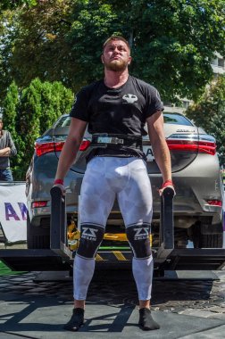 Lviv, Ukrayna - Ağustos 2017: Güçlü atlet vücut geliştirmeci Strongmen maçta coşkulu seyirci önünde Toyota otomobil asansörleri
