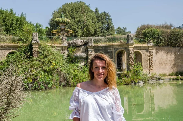 Mooi meisje op de achtergrond van een antieke fontein tijdens het wandelen in het park van Villa Doria Pamphili in Rome, Italië — Stockfoto