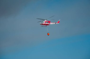 Roma, İtalya - Temmuz 2017: İtfaiyeci helikopter kurtarma işlemi toplar su Tiren Denizi ve Ostia, İtalya için doğal afet ortadan kaldırarak yangın söndürme sırasında