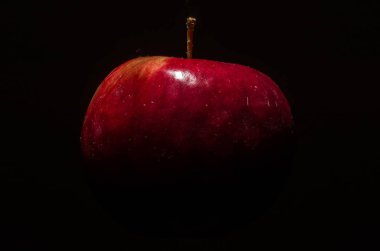 Düşük bir anahtar içinde siyah bir zemin üzerine izole Kırmızı elma