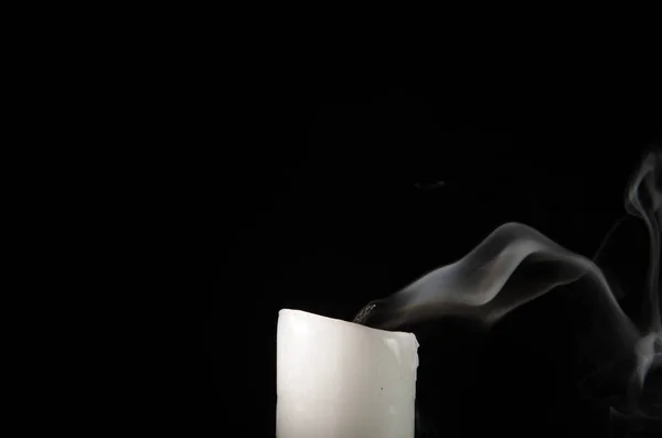 Kynttilän polttaminen hiipuvalla liekillä ja savulla mustalla taustalla — kuvapankkivalokuva