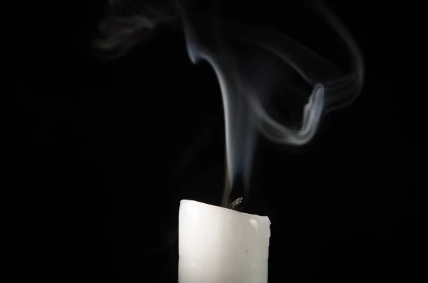 Kynttilän polttaminen hiipuvalla liekillä ja savulla mustalla taustalla — kuvapankkivalokuva