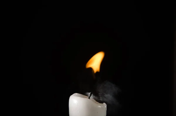 Burning candle with fading flame and smoke on a black background — Stock Photo, Image