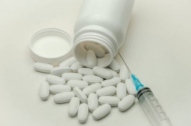 İlaçlar, vitaminler ve enjeksiyon için şırınga beyaz arka planda izole edilmiş ilaçlar