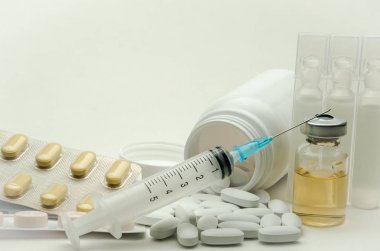 İlaçlar, vitaminler ve enjeksiyon için şırınga beyaz arka planda izole edilmiş ilaçlar