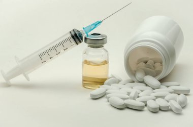 İlaçlar, vitaminler ve enjeksiyon için şırınga beyaz arka planda izole edilmiş ilaçlar